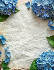 Crumpled paper background framed by blue hydrangea flowers.