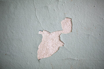 Cracked, peeling paint on the wall. A wall with old cracked blue paint. Patterns of cracks.