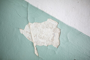 Cracked, peeling paint on the wall. A wall with old cracked blue paint. Patterns of cracks.