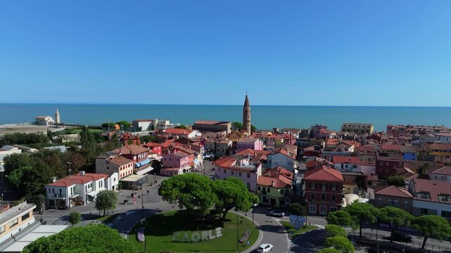 rising aerial in Caorle, Italy, view of the Campanile del Duomo and the Adriatic Sea