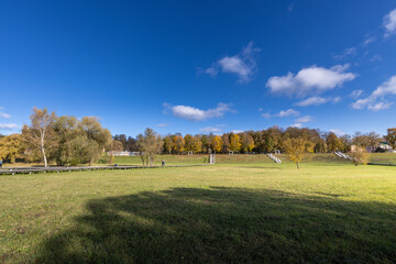 A large field with a blue sky and trees