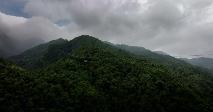 Drone view of Sapa Fansipan gondola moving toward lush summit, Lao Cai, Vietnam