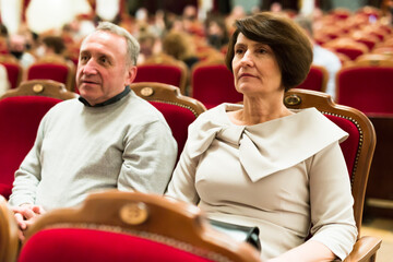 Elderly couple watching play in the theater