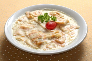 Brie cheese raviolini with Alfredo sauce on plate