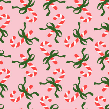 Seamless pattern with Christmas candy canes and bows on pink background. Cute background design for fabric, wrapping paper, textile, wallpaper