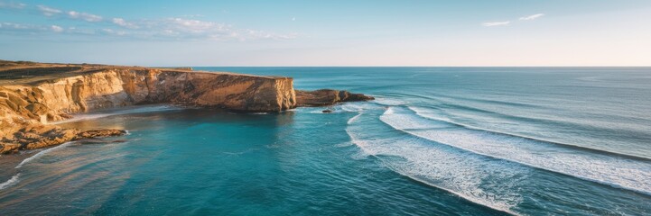 A banner with sea coasts. A bird's-eye view of the sea waves washing the rocky shore is captured. The ocean is calm in sunny weather.