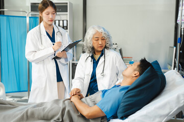 doctor talking to male patient at bed in hospital.