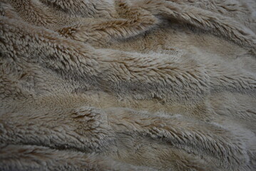 Fabrics, soft materials, bedspread, blanket made of synthetic materials. Gray-brown, fluffy and...