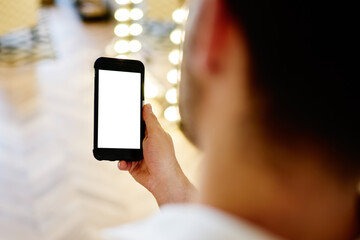 Guy watching cellphone in room in sunny day