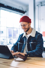 Smiling young hipster using tablet