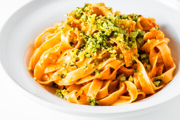 italian tagliatelle pasta with tomato sauce and basil parmesan on white. restaurant recipe