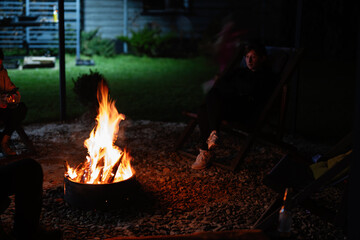 Cozy evening by a campfire with friends in a backyard setting