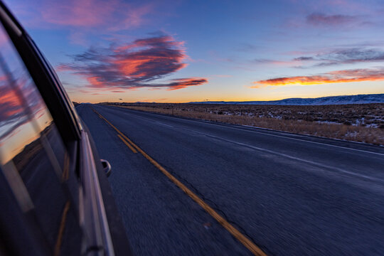 Blurred rural highway seen from moving car at dusk