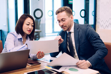 Young coworkers discussing project in office