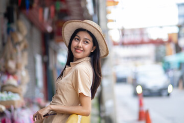 Fototapeta premium A woman wearing a straw hat is smiling in front of a store