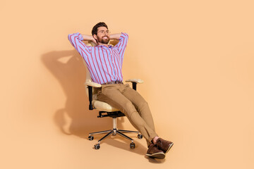 Photo of brunet successful entrepreneur man wearing formal outfit chill out at office sitting armchair isolated on beige color background