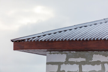 A roof covered in snow and a brick wall