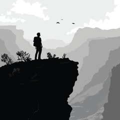 Silhouette of a hiker standing at the edge of a cliff