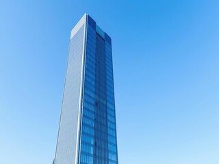 Obraz premium Office building with a sleek modern design standing tall against a clear blue sky, commercial