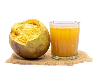Ripe Indian Bael Fruit Juice or Sharbat in a Glass or Wood Apple Isolated on White Background with Copy Space, Also Known as Aegle Marmelos, Bengal Quince, Japanese Bitter Orange or Stone Apple