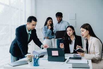 Business Collaboration: A dynamic team of professionals huddle around a tablet, engaged in a collaborative brainstorming session. They share ideas, analyze data, and strive for innovative solutions.