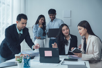 Collaborative Brainstorming:  A diverse team of professionals huddle around a table, engaged in lively discussion, laptops and notebooks at hand, as they brainstorm ideas and solutions.