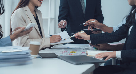 Teamwork Makes the Dream Work: A diverse group of business professionals collaborate in a modern office setting, engaged in a focused discussion, showcasing the power of teamwork and shared ideas.