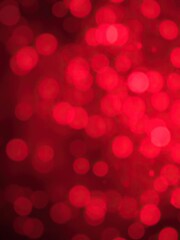 Red bokeh snowflakes background with soft blurred lights and shining particles, holiday