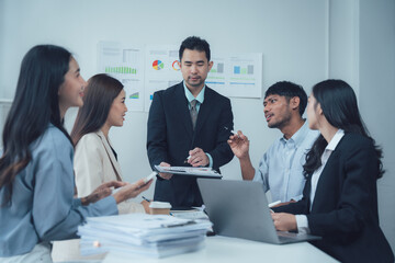 Strategic Business Meeting: A diverse team collaborates around a table, engaged in a lively discussion, showcasing professionalism and teamwork in a modern office setting.
