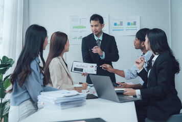Business Meeting: A diverse team of business professionals engaged in a productive meeting, discussing strategies and data, showcasing a collaborative and professional work environment. 