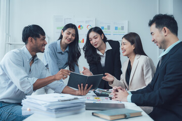 Fototapeta premium Teamwork Makes the Dream Work: A diverse business team collaborates around a table, engaged in a lively discussion, fostering a spirit of unity and shared goals. 