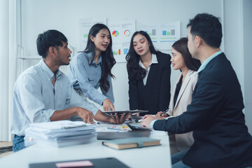 Collaborative Business Meeting: A diverse team of professionals engages in a productive meeting, reviewing data on tablets and discussing strategies.