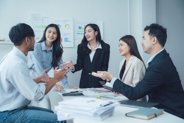 Business Meeting: A diverse team of professionals engage in a lively discussion, sharing ideas and collaborating on a project, reflecting a dynamic and inclusive work environment. 