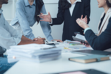Business Meeting: A diverse group of professionals huddle around a conference table, engaged in a...