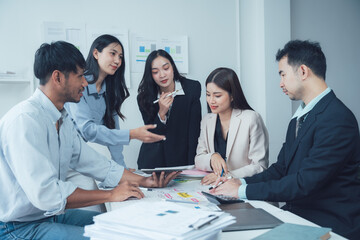 Business Meeting: A diverse team of professionals collaborates on a project, analyzing data and brainstorming ideas in a modern office setting.