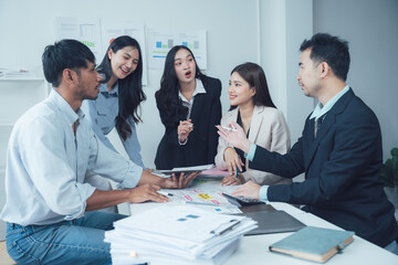 Dynamic Business Team Brainstorming: A diverse group of young professionals collaborates around a table, engaging in lively discussion and brainstorming.  Their energy and focus are palpable.