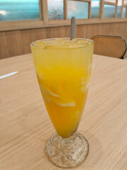 photo of a fresh orange iced drink mixed with shavings of young coconut meat
