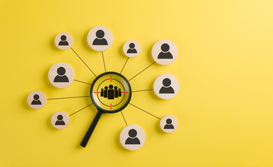 Target audience and customer focus concept. A black magnifying glass highlighting a group of people...