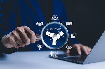 Teamwork and collaboration concept. Businessman holds magnifying glass focused on "Teamwork" icon symbols collaboration, communication, and idea sharing. teamwork in achieving organizational goals.