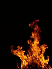 Flames of fire bursting on a dark black backdrop, danger