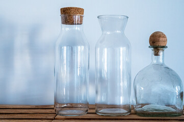 Three glass bottles of different shapes on a white background. Empty bottles