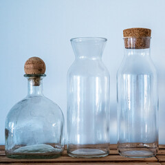 Three glass bottles of different shapes on a white background. Empty bottles