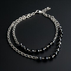 Fototapeta premium Silver chain with black spinel beads edgy and elegant on plain black dark background