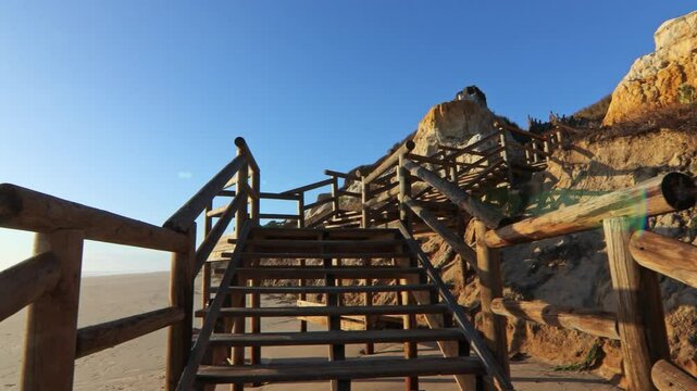 Walkway with wooden steps on Cuesta Maneli beach, located in a very unique environment, the fossil dune system of El Asperillo, located within the Do&ntilde;ana Natural Park , Huelva, Spain.