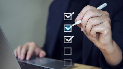 Businessman use pen to tick correct sign mark in checkbox for quality document control checklist...