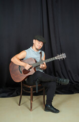 Obraz premium Musician playing an acoustic guitar in a casual studio