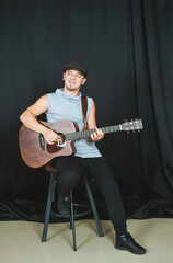 Obraz premium Musician playing an acoustic guitar in a casual studio