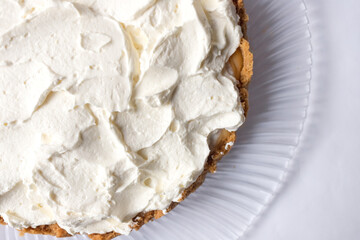 Banoffee banana pie with caramel sauce and cheese cream on the white background. Traditional english cake. Ready to eat. Cooking concept