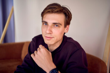 portrait of an attractive young 20 year old man with dark hair and blue eyes, studio photo shoot