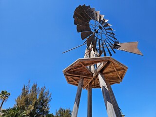Une imposante éolienne en bois à Costa Teguise se détache sur un ciel bleu éclatant, avec ses...